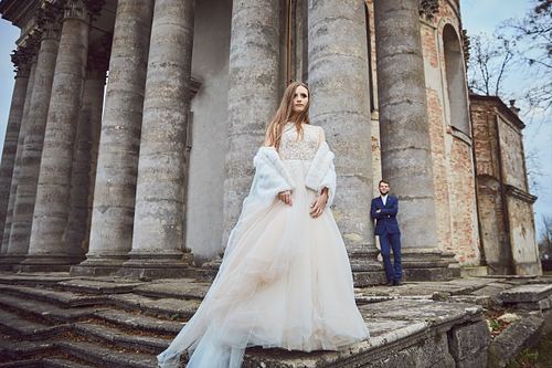 Elegant bridal portrait among historic architecture in Pidhirtsi