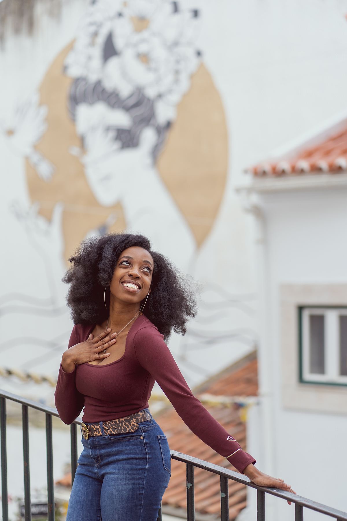 Woman posing beside a mural in Alfama, Lisbon