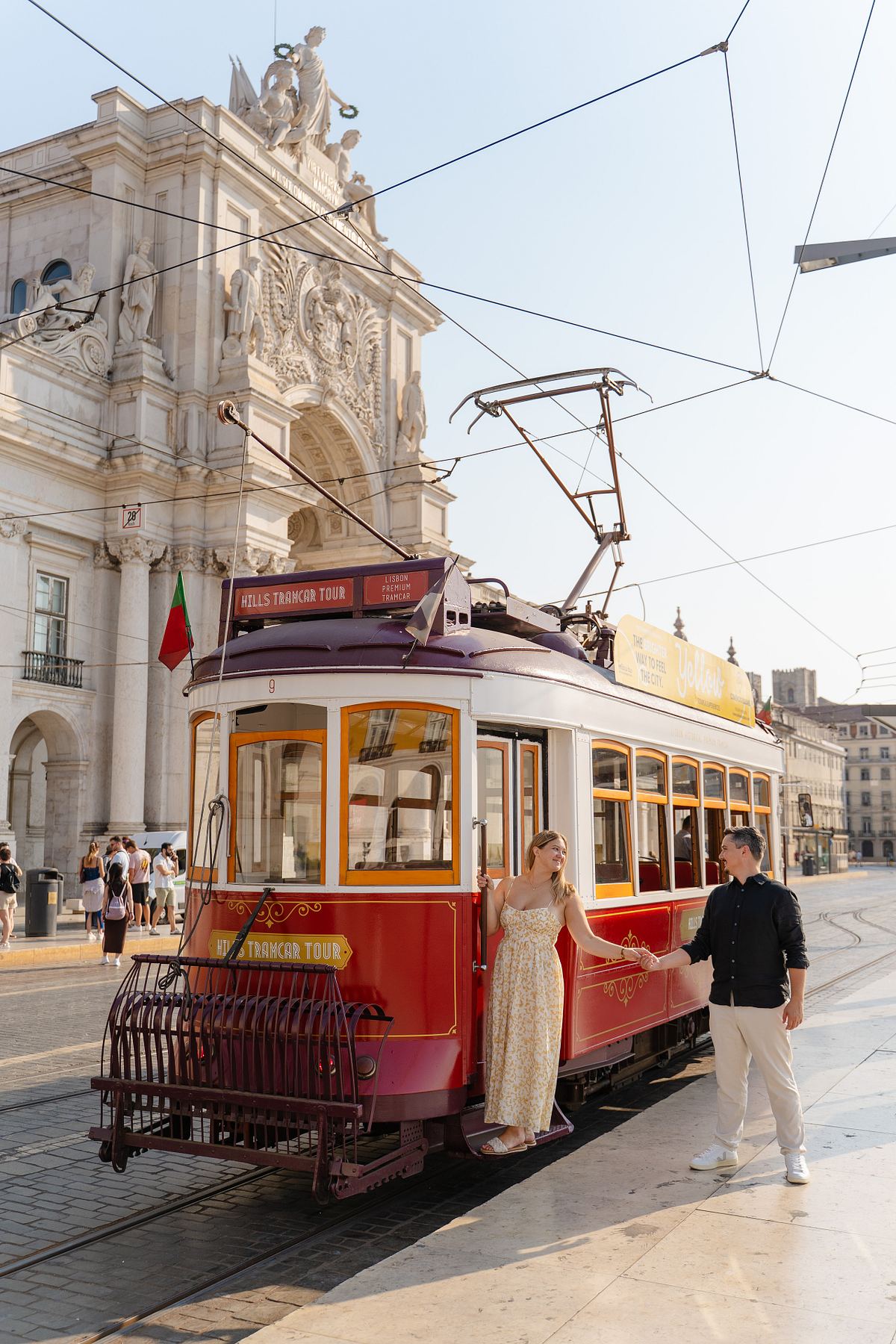 Classic yellow tram passing through a Lisbon street