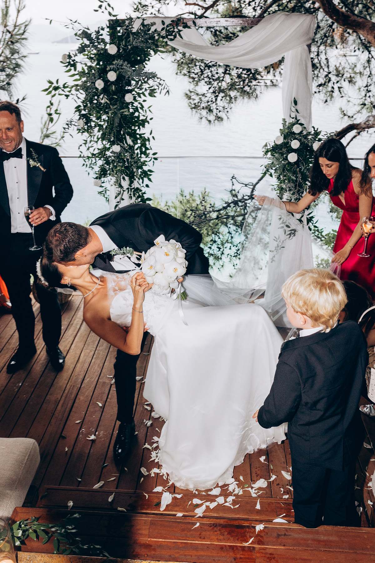 Groom dipping the bride after their seaside wedding ceremony in Göcek
