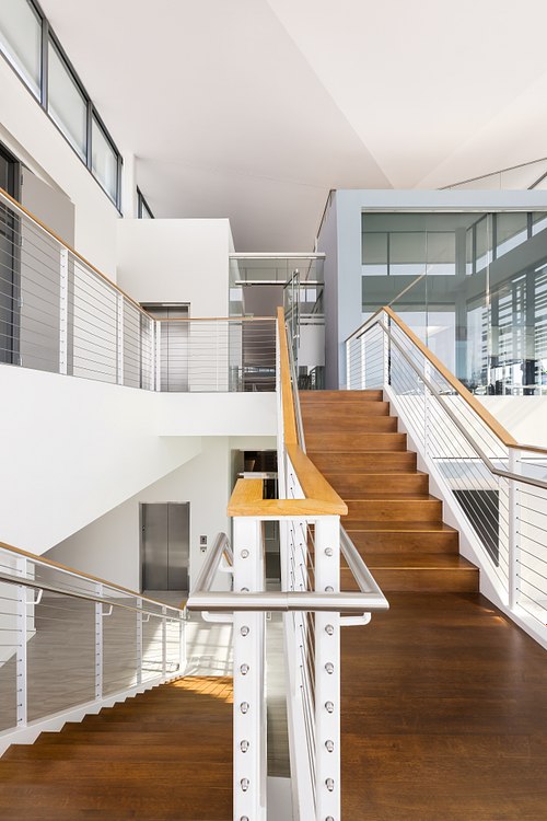 Modern wood and glass staircase inside the Florida Public Utilities headquarters in Wildlight.