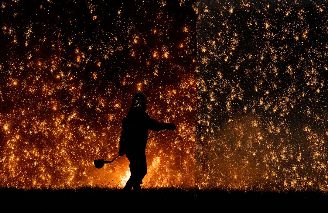 Ironworker Silhouetted Against Fire and Sparks