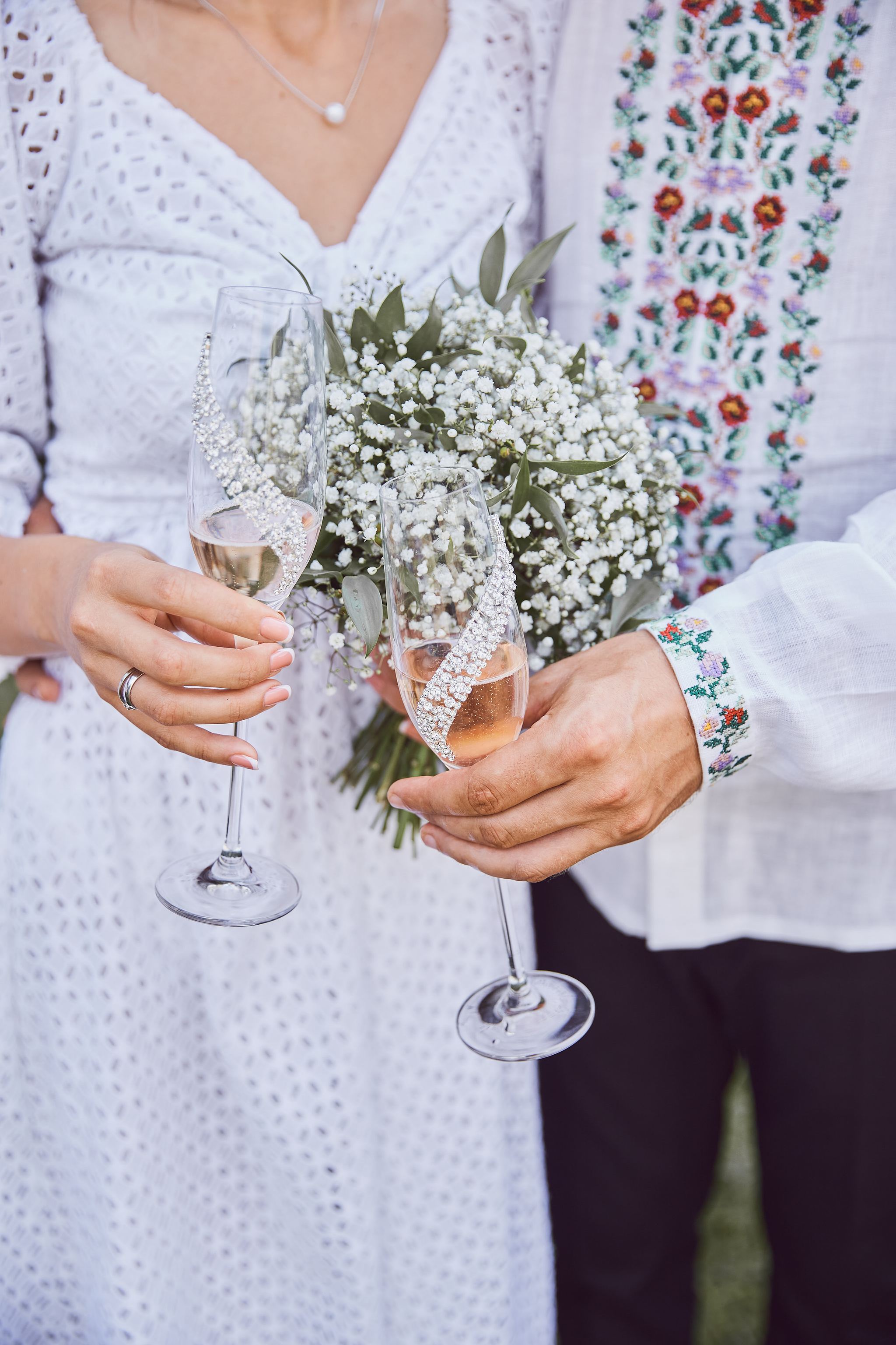 Bride and groom holding champagne glasses together