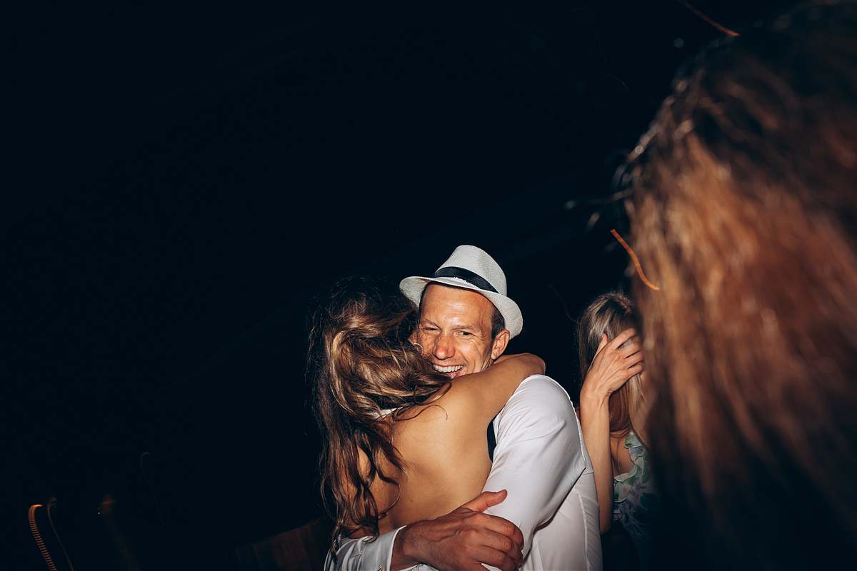Groom embracing a guest on the evening dance floor