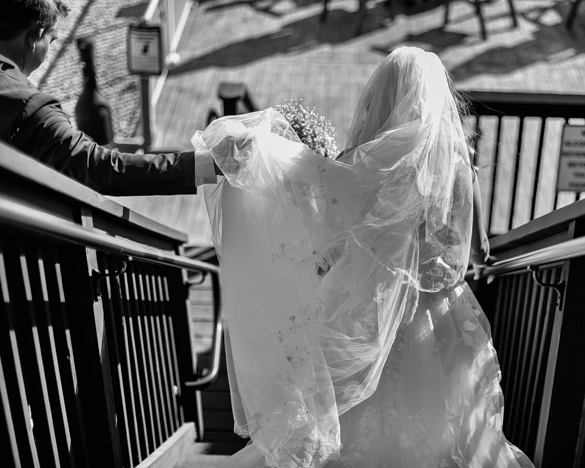 private moment of bride and groom walking down the stairs at the Irish Penny, lewes, de, black and white