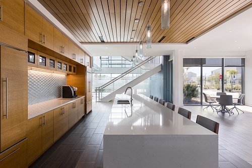Second angle to modern commercial kitchen and interior stairwell lobby at the FPU Headquarters in Yulee, Florida, designed by Polk Stanley Wilcox Architects.