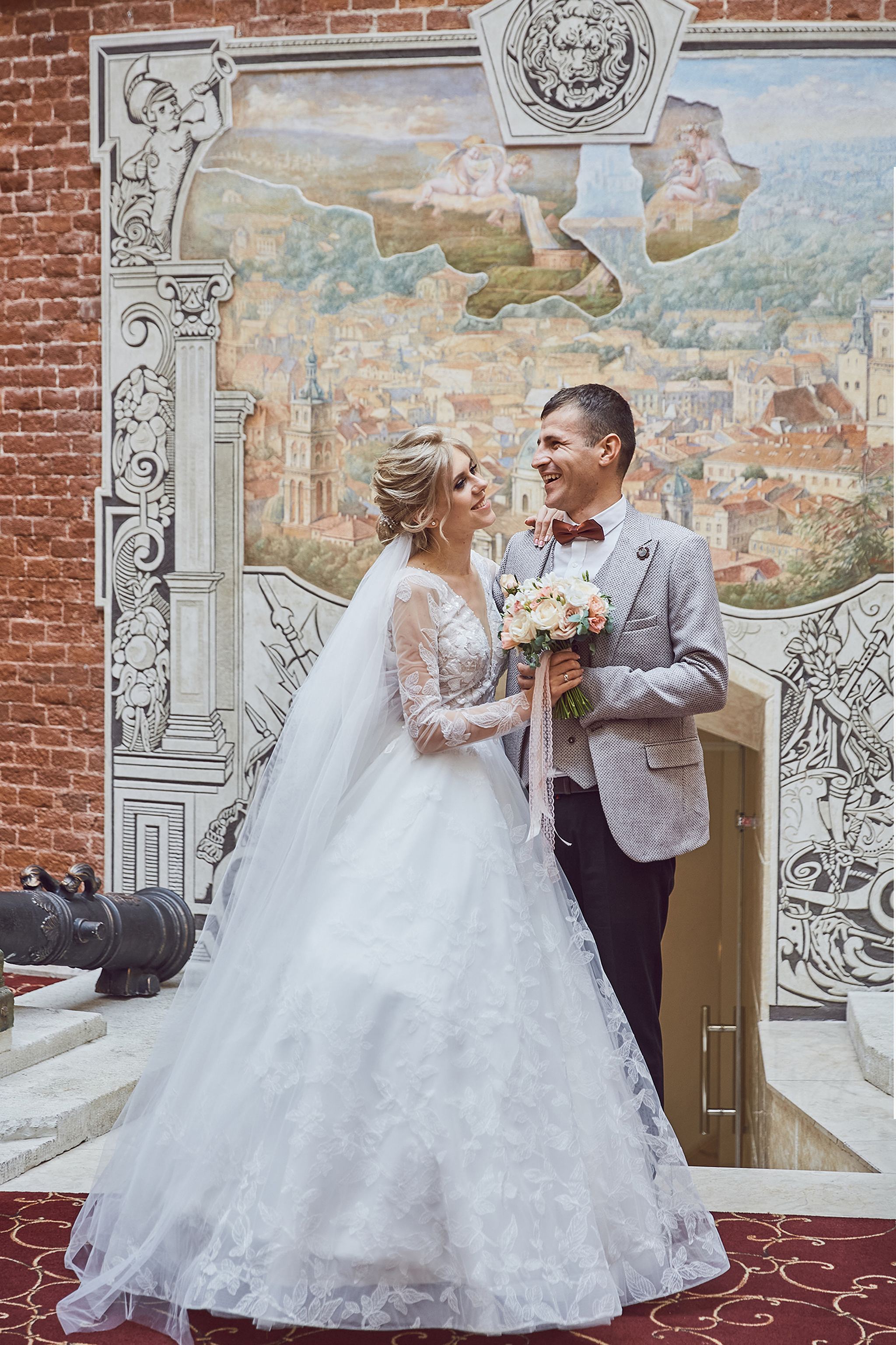 Joyful bride and groom portrait against an artistic mural