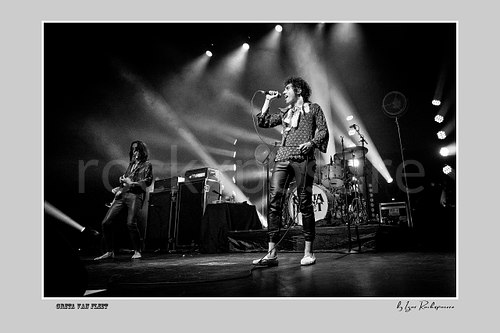 Horizontal black and white image of Greta Van Fleet members Sam Kiszka and Josh Kiszka performing on stage