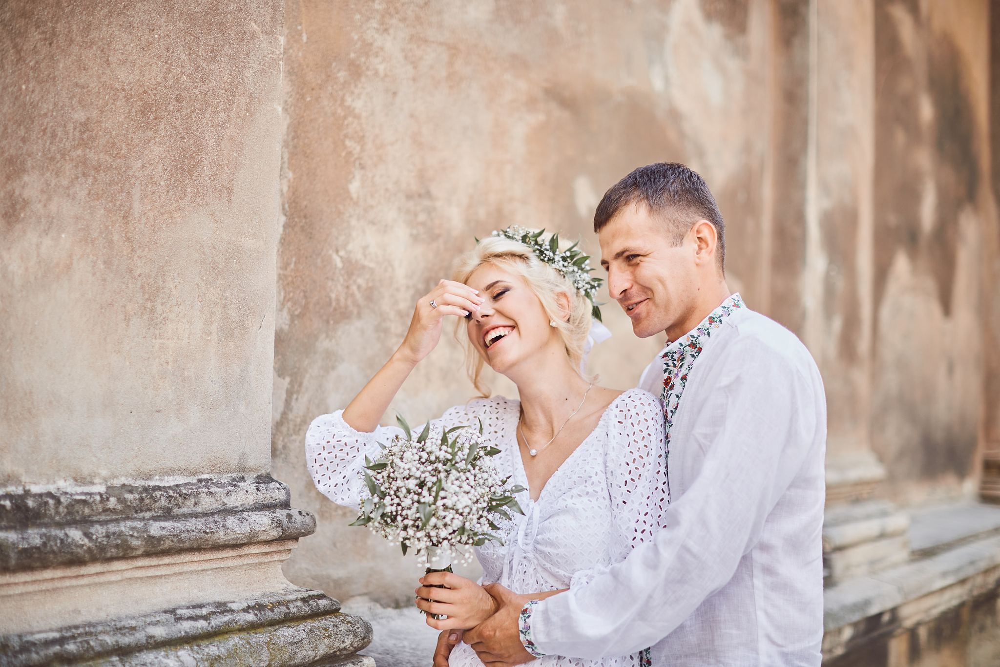 Bride laughing while standing beside the groom