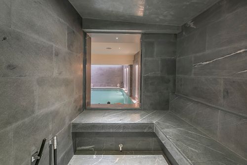 Entrée du sauna avec murs en marbre gris dans un appartement haussmannien sur les Champs-Élysées, Paris. Photographie d’architecture intérieure par Nicolas Karadimos.