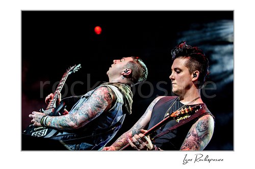 Horizontal color image of Zacky Vengeance and Synyster Gates of Avenged Sevenfold playing guitar on stage together in a tight close-up