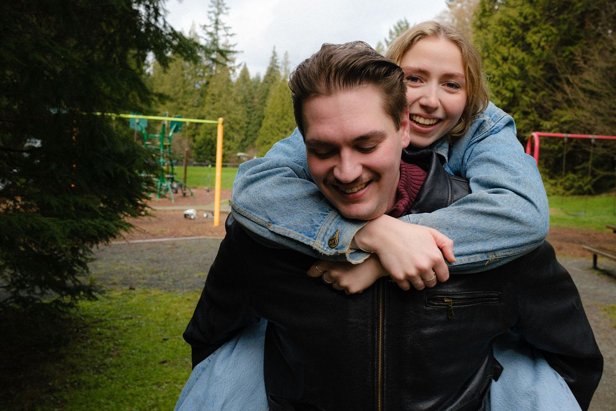 couple having fun as girlfriend catches a piggy back ride