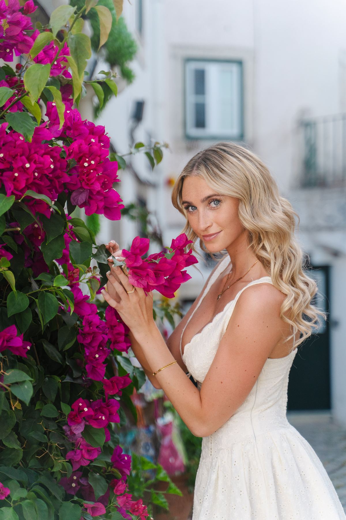 Woman in a white dress beside bougainvillea in Lisbon