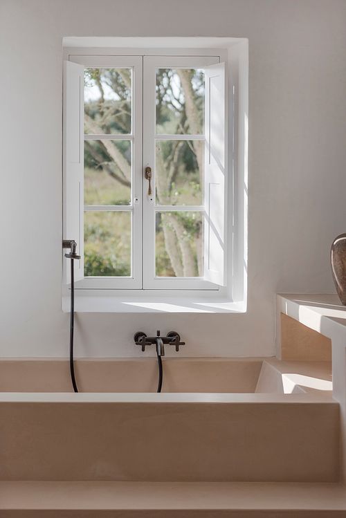Salle de bains de la finca d’agrotourisme à Santa Ponça, Minorque, avec baignoire et fenêtre ouverte sur l’extérieur. Photographie par Nicolas Karadimos.