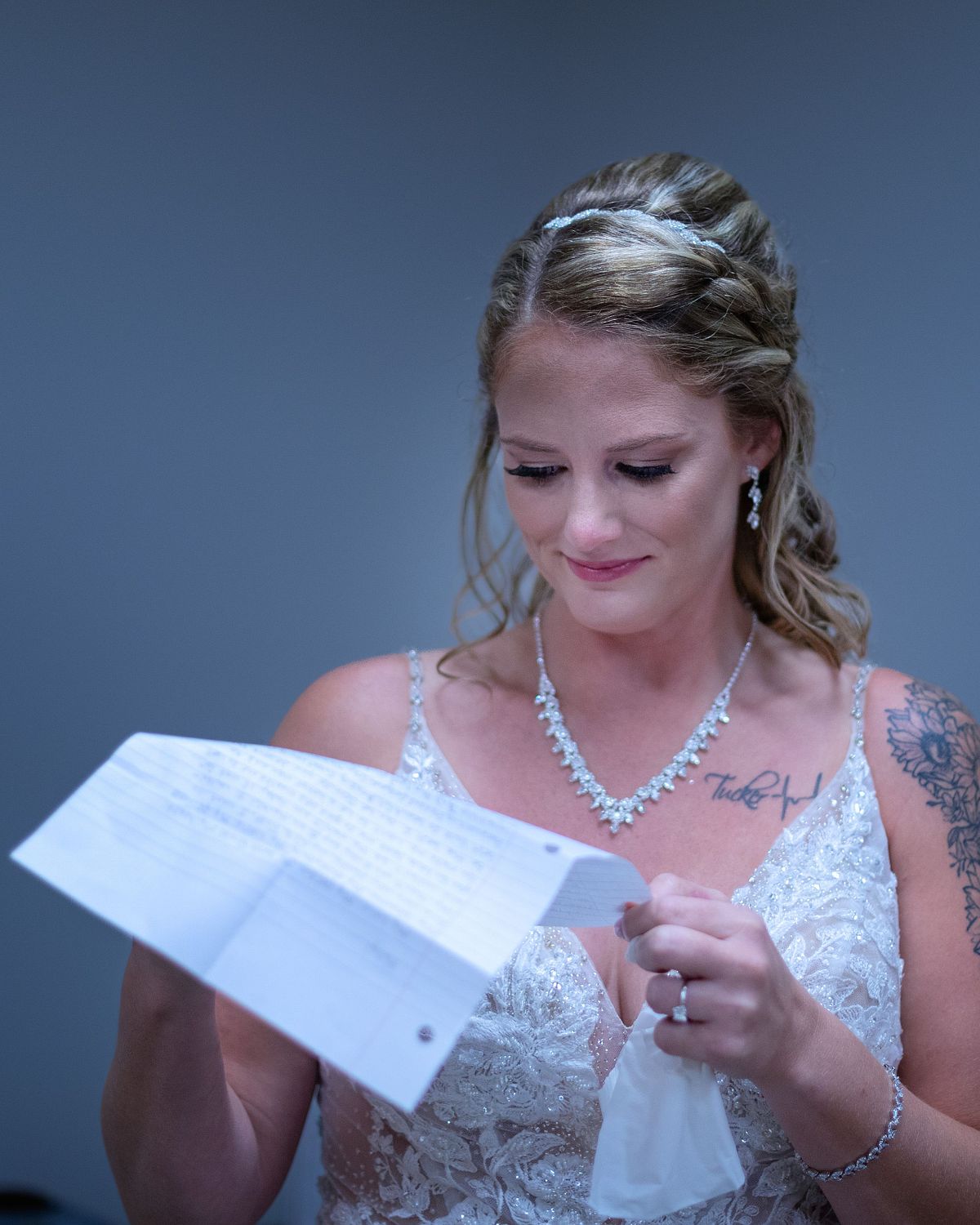 bride is reading a letter from her fiance' before the ceremony at ross station, she is smiling and emotional