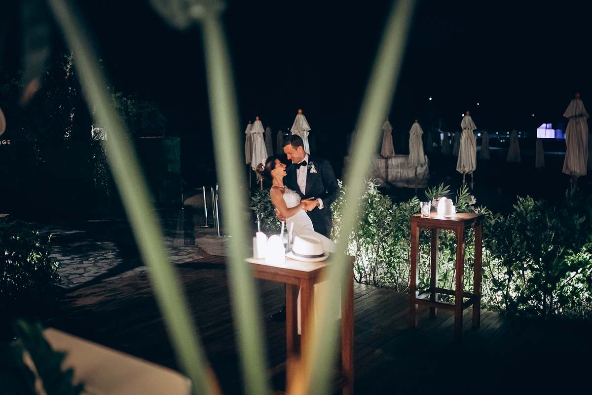 Bride and groom beside their wedding cake during the evening celebration