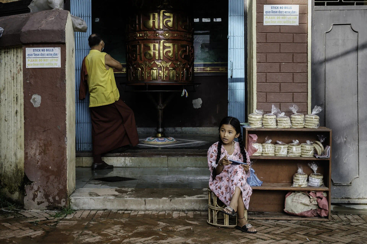 The girl is sitting, the monk is standing, both static: this frame was shot at 1/150s.