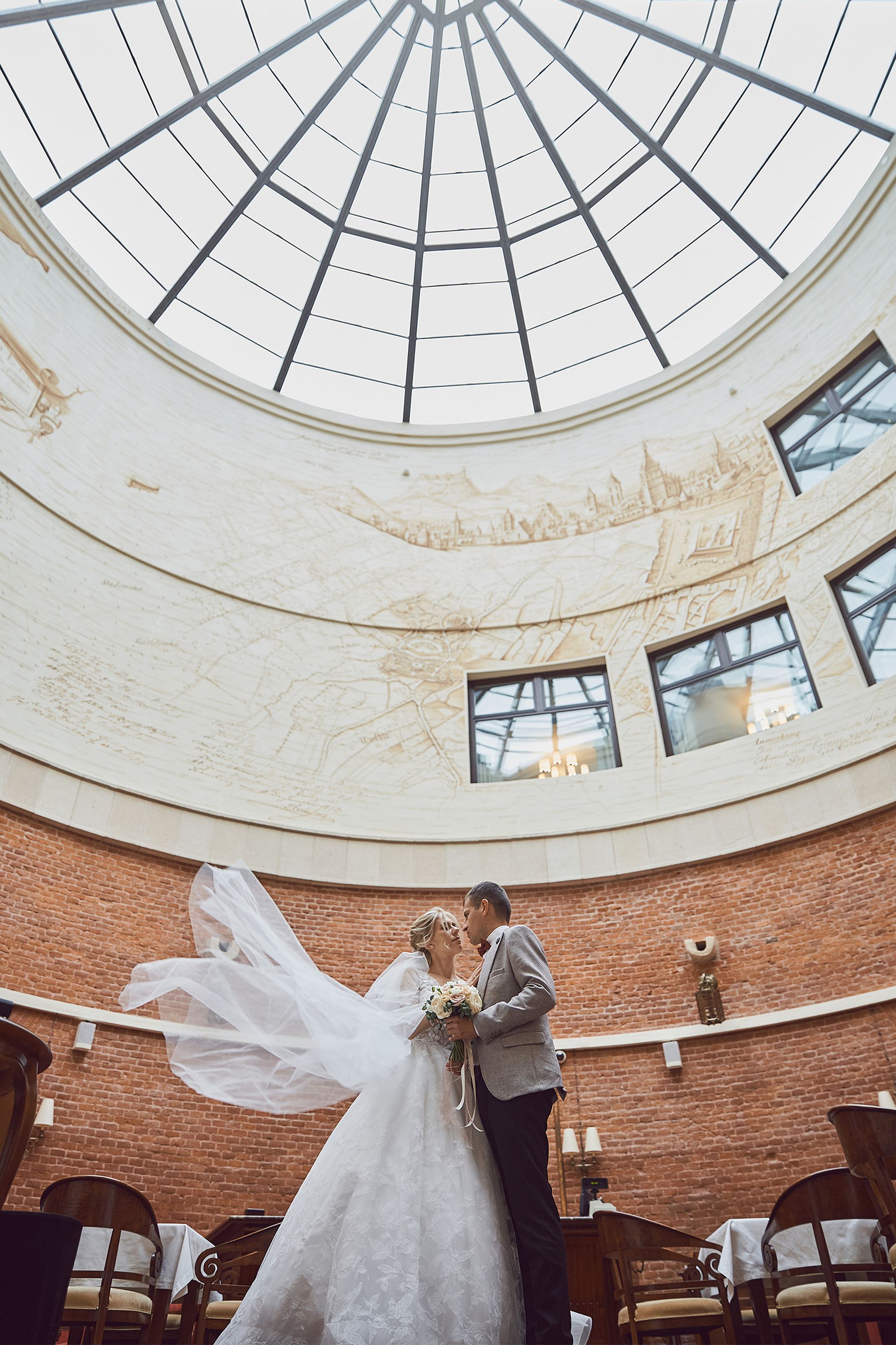 Bride and groom beneath the glass atrium at Citadel Inn