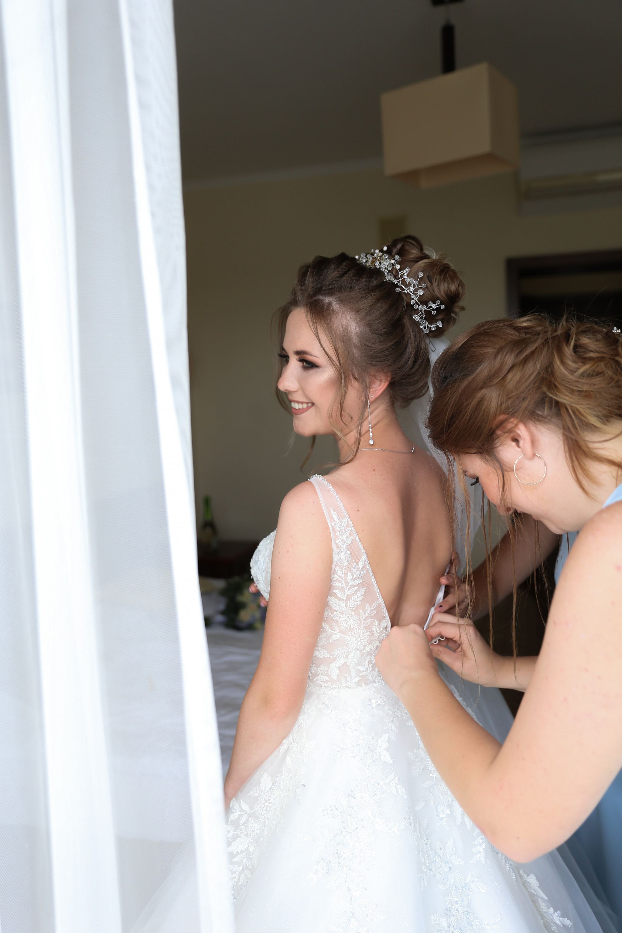 Bride getting ready with her bridesmaids on the wedding morning