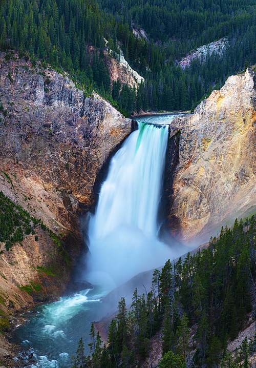 A vertical close-up fine art landscape photograph of the Lower Falls of the Yellowstone River, showing powerful white water plunging down the rugged canyon walls of Wyoming.