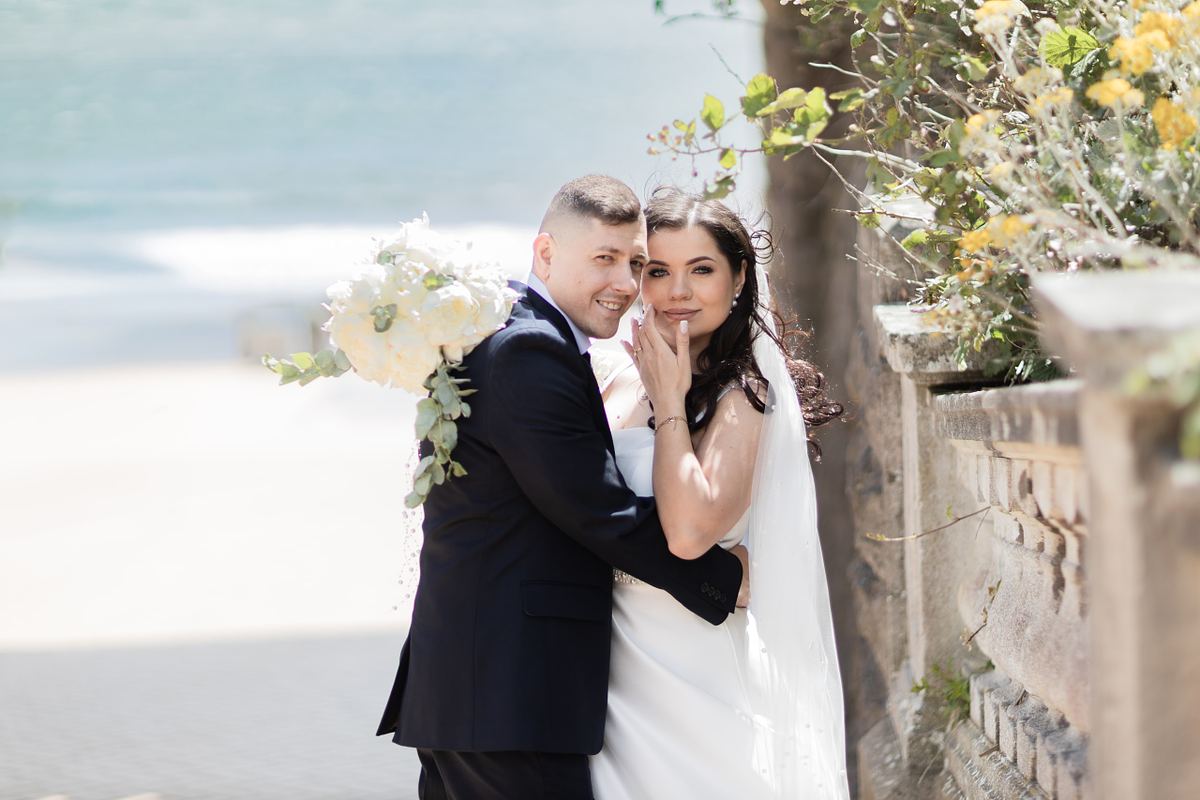 Bride and groom embracing beside the seafront at Barry Island, photographed by Marta Vershynina South Wales wedding photographer