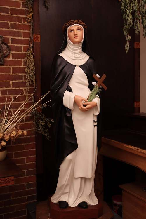 Saint Catherine Statue Restoration after repainting by Kelly Baker of Contrasts Woodcarving for Holy Trinity Catholic Church in Somerset, Ohio.