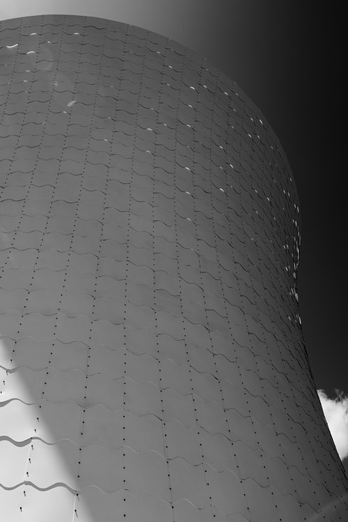 Vertical perspective showcasing the curved facade and structural form of JEFRË's The Beacon tower in Lake Nona.