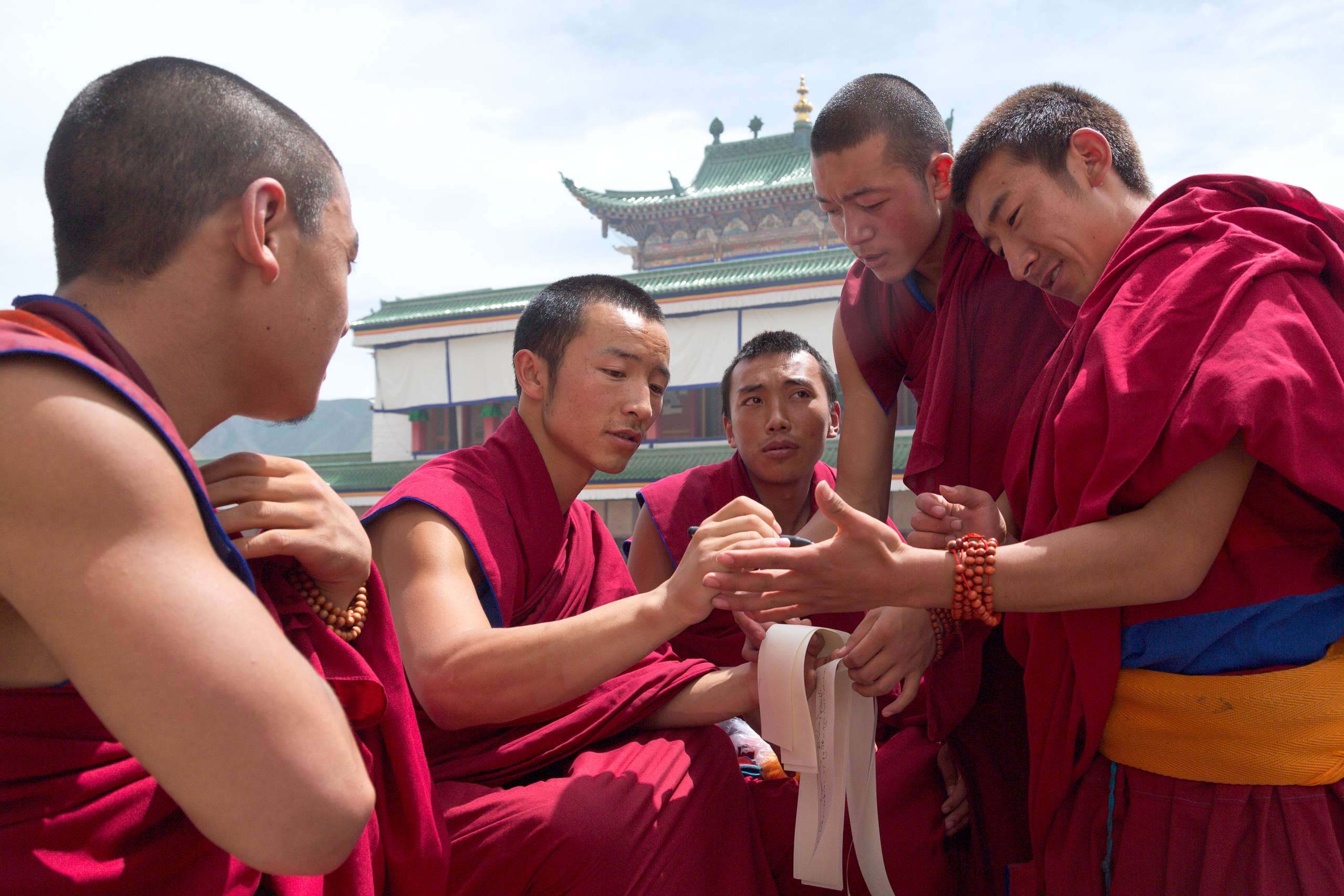 A group of Tibetan Gelug monks gathered in a temple at Labrang Monastery in Xiahe, Gansu, China.