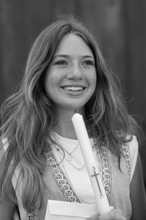 Portrait en noir et blanc d’une jeune femme souriante.