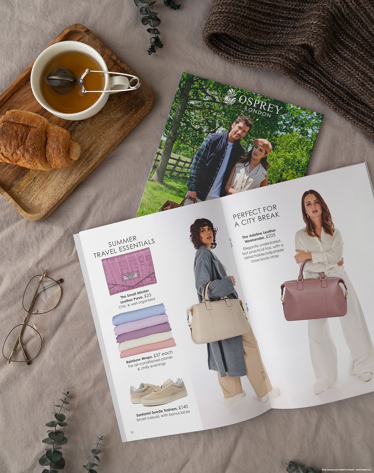 breakfast table with croissant, tea, glasses and an open leather accessories catalogue