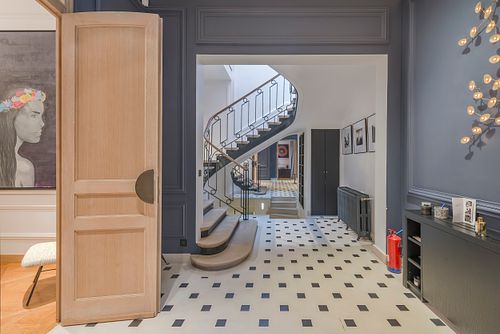 champs-elysees, entrée haussmannienne, escalier courbe, sol damier, architecture intérieure paris, intérieur luxe, immeuble haussmannien, photographie architecture intérieure, nicolas karadimos, décoration parisienne, paris 8e