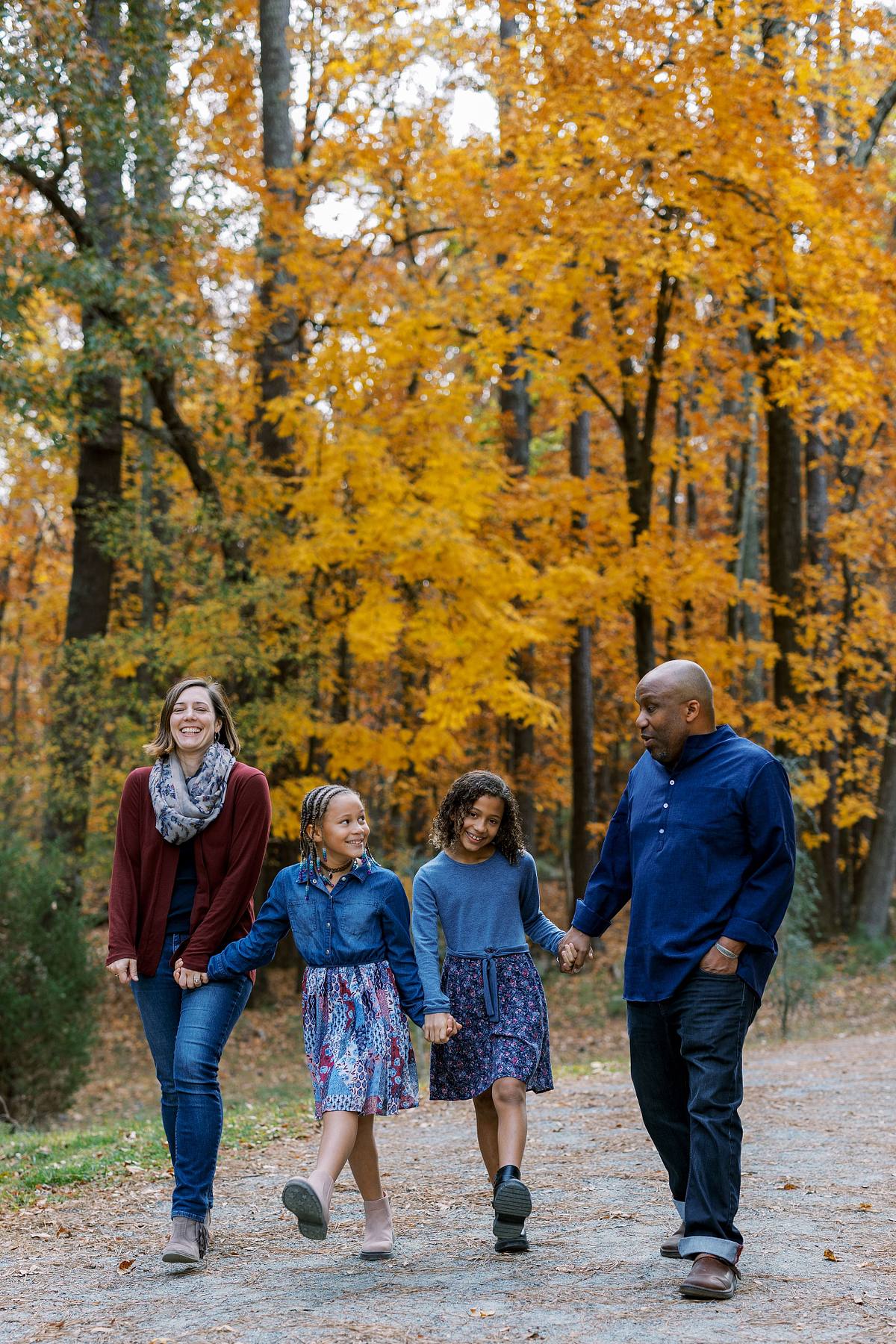 A family walking through the fall foliage in Dr. Martin Luther King Jr. Park in Carrboro, NC