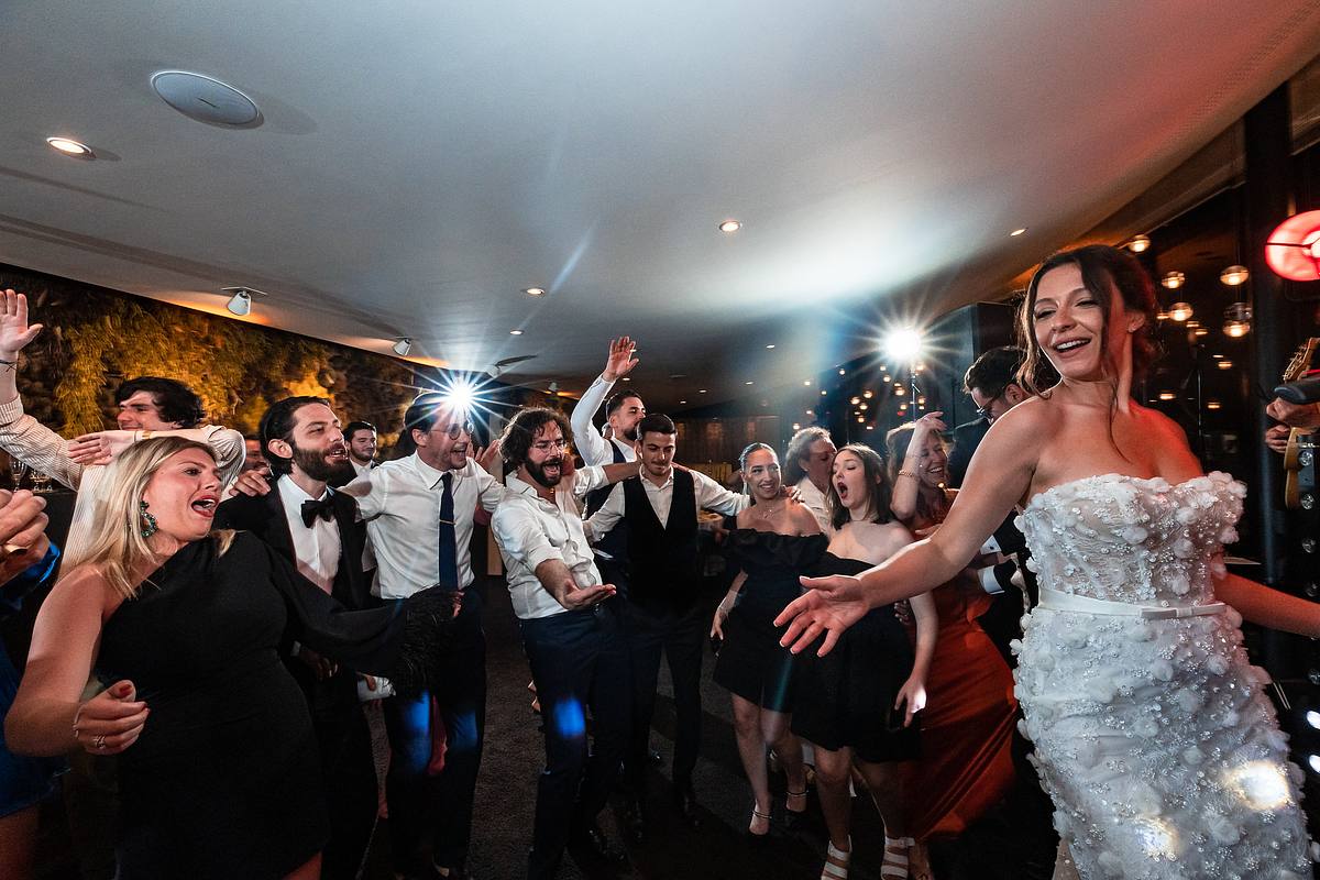 La mari&eacute;e, entour&eacute;e d'invit&eacute;s en liesse, rit aux &eacute;clats dans une ambiance de f&ecirc;te irr&eacute;sistible au Pavillon du Casino Lyon vert, une joie contagieuse captur&eacute;e par Sebastien CLAVEL Photographe mariage Lyon