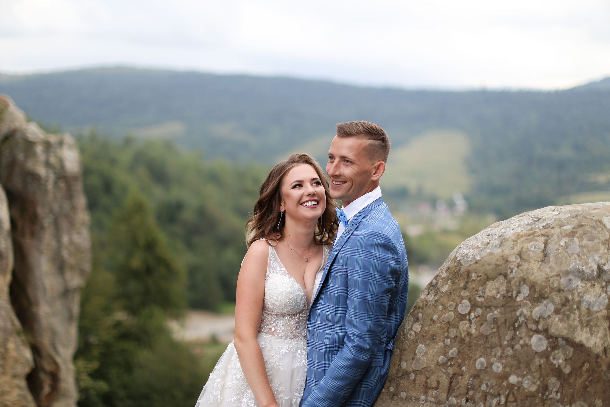 Bride and groom overlooking the mountain landscape at Tustan Fortress, Ukraine