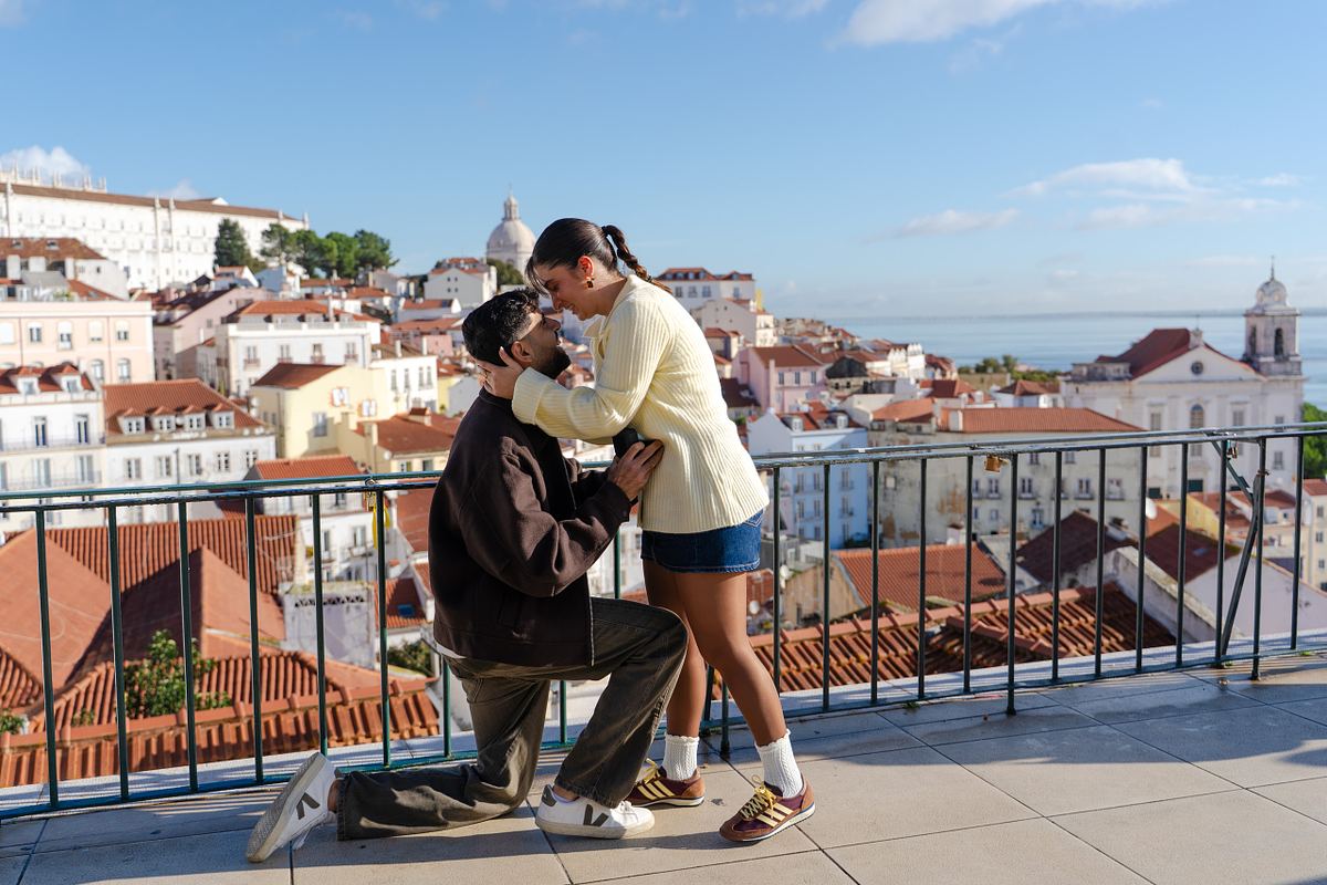 Woman embracing her partner during a surprise proposal at an Alfama viewpoint