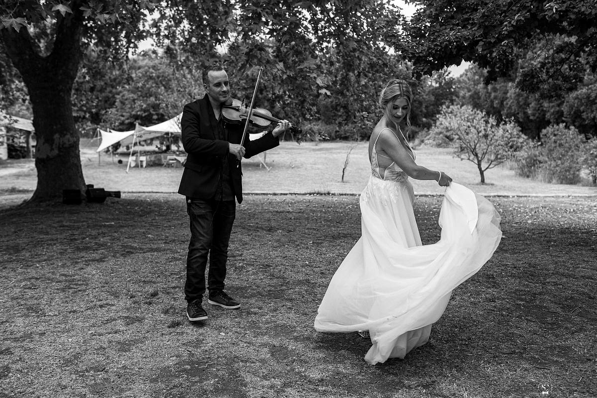 Mari&eacute;e faisant tournoyer sa robe en dansant, accompagn&eacute;e par un violoniste, immortalis&eacute;e par S&eacute;bastien Clavel, photographe de mariage bas&eacute; &agrave; Lyon