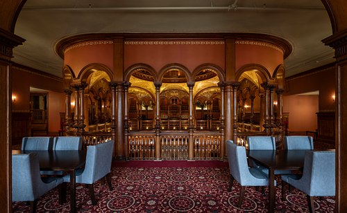 Intricate mezzanine columns framing a distant view of the grand rotunda at Flagler College, St. Augustine.