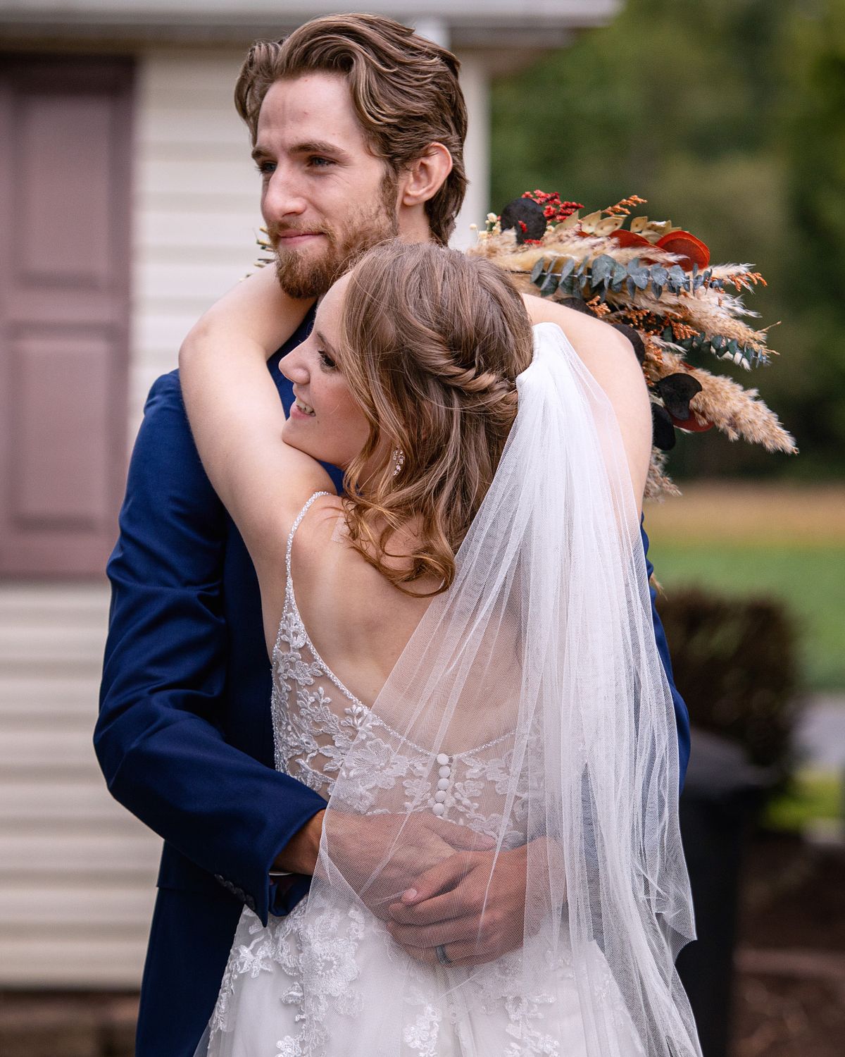 bride and groom hugging after ceremony while waiting for the guests at a farmstead wedding in Harrington, DE