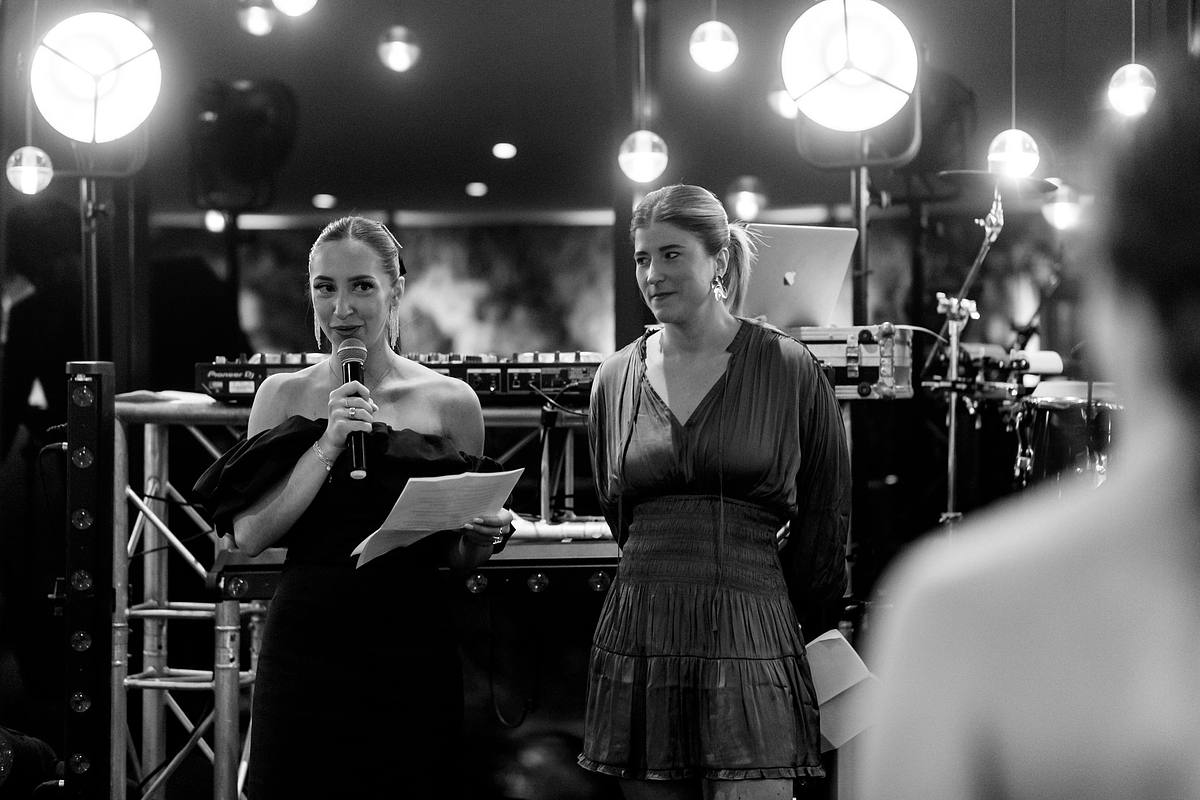 Une des t&eacute;moins de la mari&eacute;e avec une &eacute;l&eacute;gance naturelle s'adresse aux invit&eacute;s, accompagn&eacute;e d'une complice, sur fond de DJ set au Pavillon du Casino Lyon vert, un moment d'&eacute;clat par Sebastien CLAVEL Photographe mariage Lyon