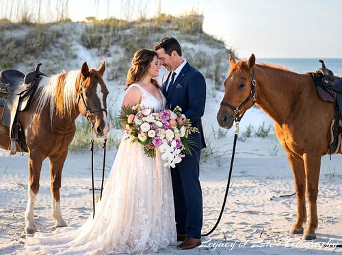Bride and groom with horses on Amelia Island Beach during a romantic sunset in Florida