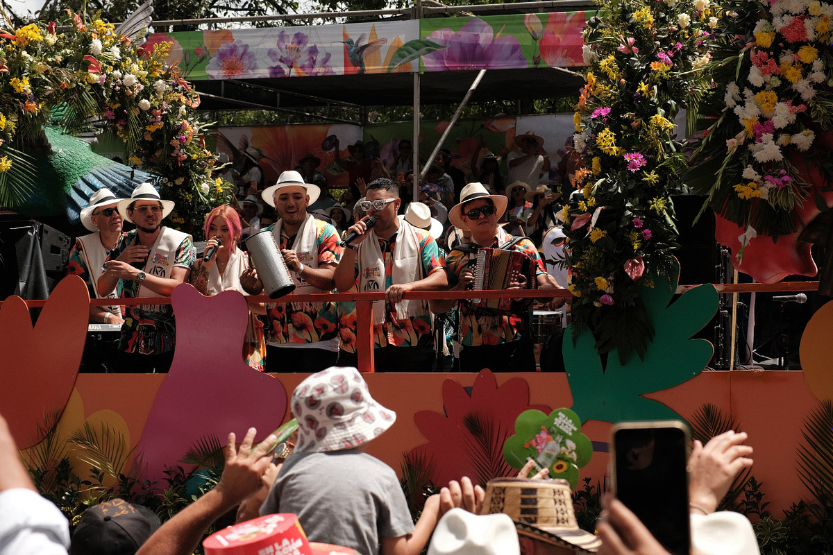 Carroza decorada con flores y músicos con sombrero durante la Feria de las Flores