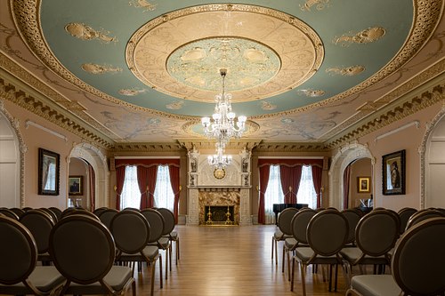 Wide view of the Flagler Room facing the windows and onyx fireplace in Ponce de Leon Hall at Flagler College.
