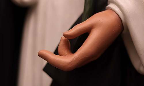 Saint Dominic statue's hand after repair and repainting.