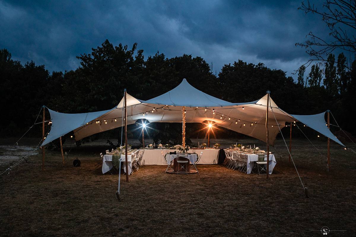 Tente de r&eacute;ception illumin&eacute;e sous le cr&eacute;puscule offrant un cadre &eacute;l&eacute;gant pour un mariage, vue par l'objectif de S&eacute;bastien Clavel, photographe de mariage &agrave; N&icirc;mes
