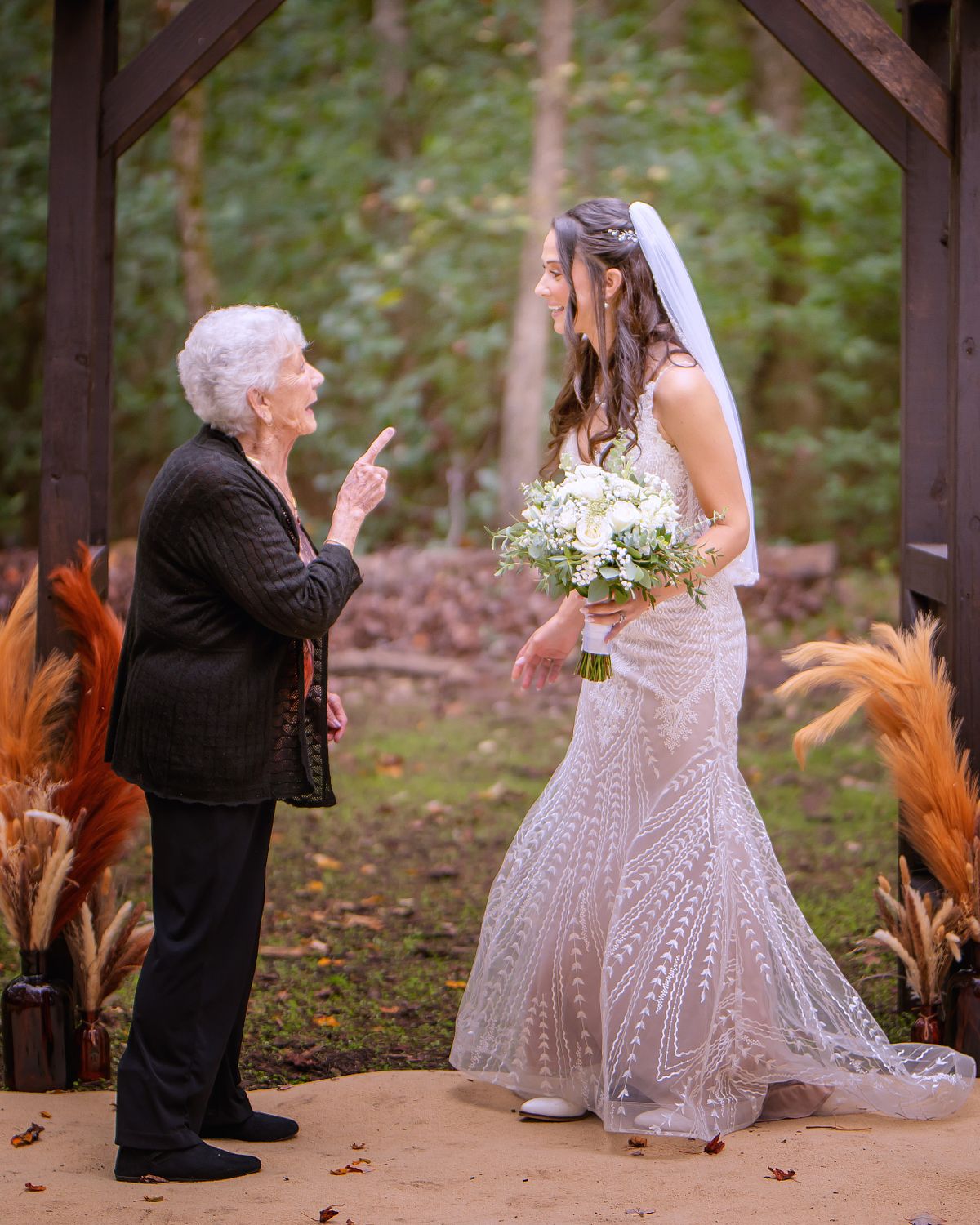 a candid moment with the bride and her grandmother underneath the arbor at a Eastern Shore wedding