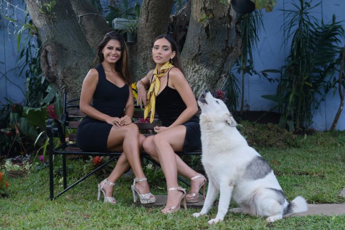 Des mannequins assis sur une chaise pour une séance photo avec un chien à côté d'eux