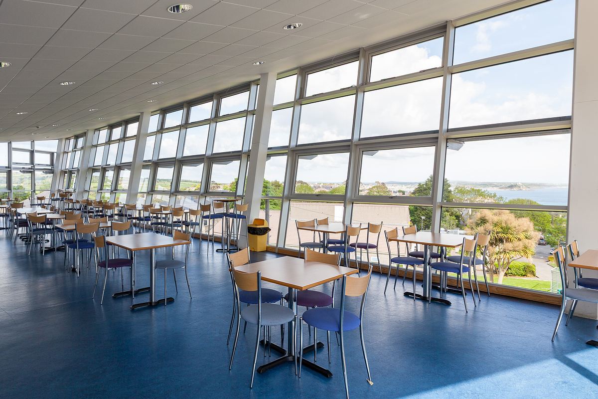Interior of Penwith College restaurant Cornwall with large glazed wall overlooking Mounts Bay.