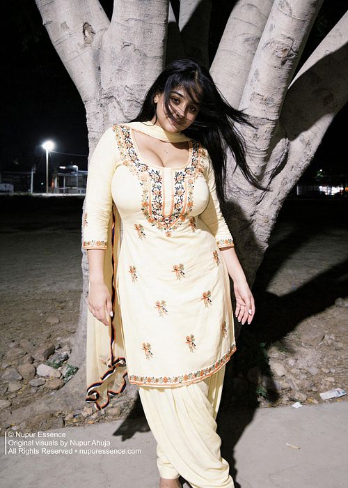 Soft smiling portrait featuring Nupur Ahuja during a nighttime Punjabi fashion shoot.