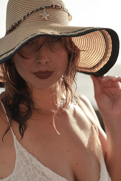 Portrait rapproché d’une femme portant un chapeau dans une douce lumière naturelle