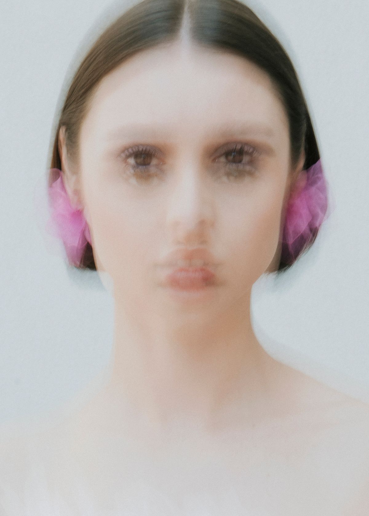 Abstract portrait of a model wearing handmade tulle earrings. Photographed by Filianna Karamanli.